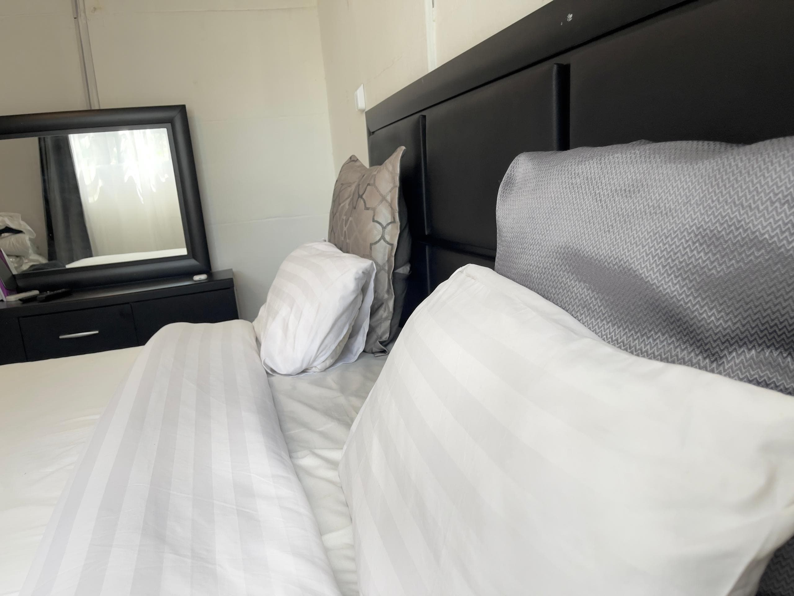 Majestic Haven — Made bed with patterned pillows at Majestic Haven apartment