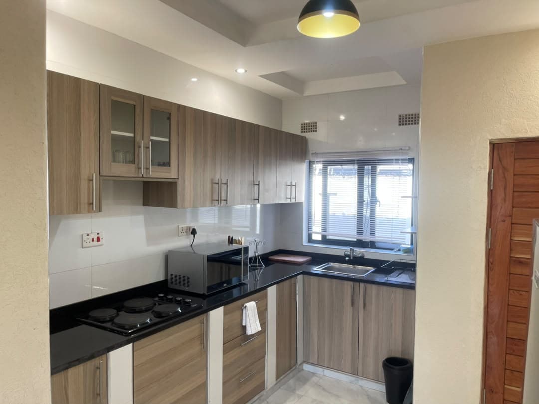Parklands Apartments Livingstone — Fitted kitchen — hob, microwave, fridge & cookware
