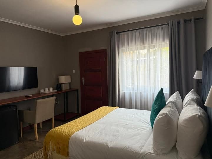 Kosha Lodges — Bedroom lounge corner with TV